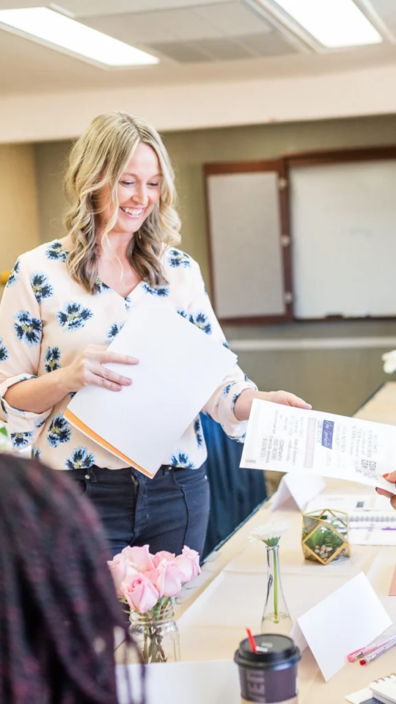 Career and business coach Anna Runyan hands out materials at a paid workshop fully booked with clients who were leads generated through her coaching website.