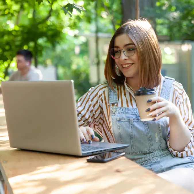 Woman Working on Computer outside with Coffee | Iterateology.com